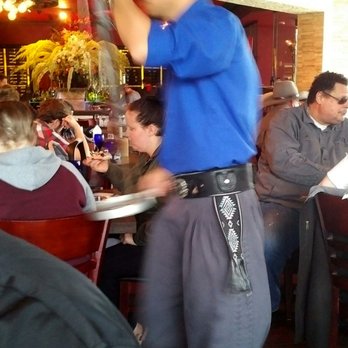 Texas de Brazil - Gaucho serving bacon wrapped chicken to nearby table. - Brazilian Near Me - Columbus, Ohio Texas de Brazil - Gaucho serving bacon wrapped chicken to nearby table. - Brazilian Near Me - Columbus, Ohio