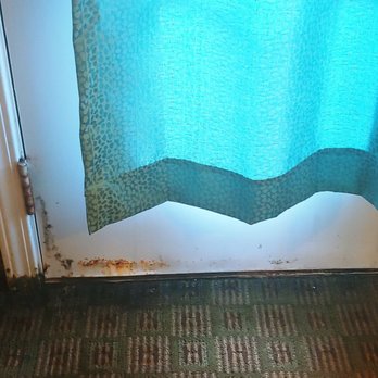 Bedford Inn - The door to the patio. Carpeting near the damaged corner is very stiff. - Hotels Near Me - Erie, Michigan