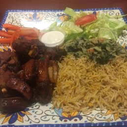 a plate of food with meat, rice and vegetables