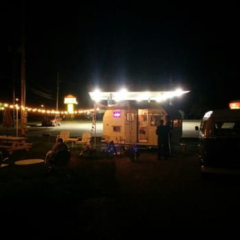 Sally's By The Shore - a couple of people sitting at a table in front of a food truck - Ice Cream & Frozen Yogurt Near Me - Rochester, Indiana Sally's By The Shore - a couple of people sitting at a table in front of a food truck - Ice Cream & Frozen Yogurt Near Me - Rochester, Indiana