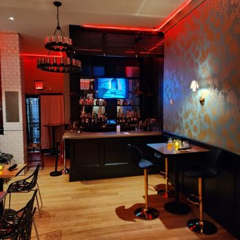 Fete - a bar with red lights and black furniture - Tapas/Small Plates Near Me - Boston, Massachusetts