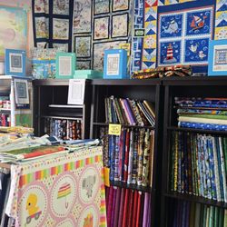 Kids Fabrics - Inside store photo showcasing quilts made from our own pre-cut quilt kits, sold in-store.