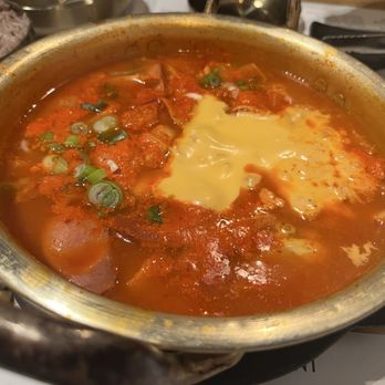 Korean Restaurant - Budae Jjigae (Army Stew) spicy stew with spam, sausage and ramen. Yellow stuff is cheese. Comfort food - Korean Near Me - Riverside, California