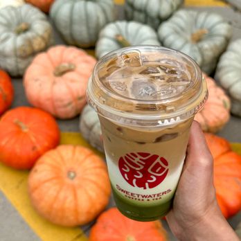 Sweetwaters Coffee & Tea - a hand holding a cup of iced coffee - Coffee & Tea Near Me - Grand Forks, North Dakota Sweetwaters Coffee & Tea - a hand holding a cup of iced coffee - Coffee & Tea Near Me - Grand Forks, North Dakota