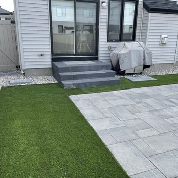 Zilite Solutions - a backyard with a patio and a fire pit - Landscaping Near Me