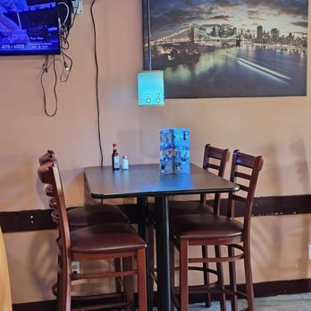 Rincon Catracho - One of the tables and chairs situated next to a wall of the restaurant with a picture decorating it. - Honduran Near Me - Roanoke, Virginia Rincon Catracho - One of the tables and chairs situated next to a wall of the restaurant with a picture decorating it. - Honduran Near Me - Roanoke, Virginia
