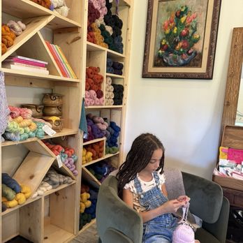 Stitch by Stitch - Inside cozy knitting spots with some malibrigo yarn peaking out on the shelves behind! - Florists Near Me - Wailuku, Hawaii Stitch by Stitch - Inside cozy knitting spots with some malibrigo yarn peaking out on the shelves behind! - Florists Near Me - Wailuku, Hawaii