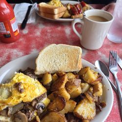 Philly cheeses teak omlette split with home fries.