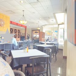 A few diners eating lunch and the wait staff standing around.