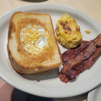 The Toasted Yolk Cafe - Eggs in a nest on sourdough toast with bacon and a sample of the hashbrown casserole - Breakfast & Brunch Near Me - Mont Belvieu, Texas The Toasted Yolk Cafe - Eggs in a nest on sourdough toast with bacon and a sample of the hashbrown casserole - Breakfast & Brunch Near Me - Mont Belvieu, Texas