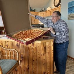 Benny Tesoro's - Man holding open the pizza box.