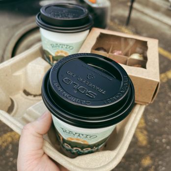 Ratio Coffee - a hand holding two cups of coffee - Coffee & Tea Near Me - Vernon, British Columbia