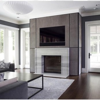 AJ Tiles - a living room with a fireplace and couches - Tiling Near Me AJ Tiles - a living room with a fireplace and couches - Tiling Near Me