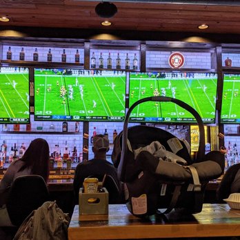 Hudson Tap - Watching the game at the bar on consecutive screens. It's a family place. - American Near Me - Hudson, Wisconsin