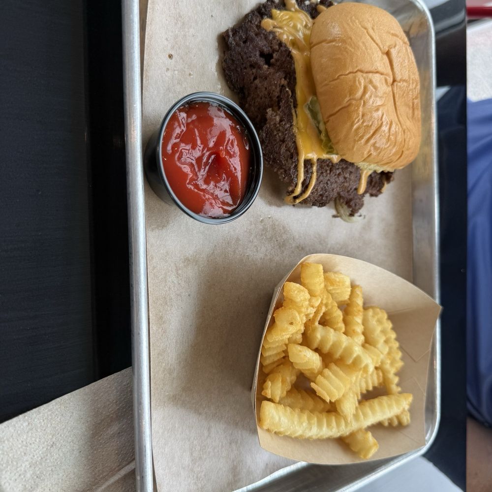 Burger and fries with grilled onions, sauce, pickles. Burger and fries with grilled onions, sauce, pickles.