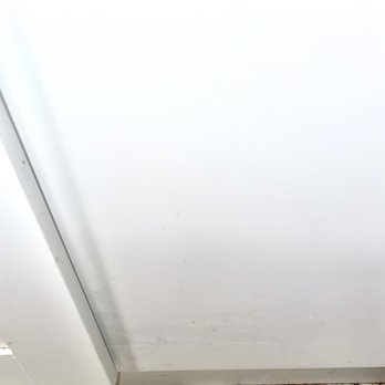 Project X Restoration - Bottom of empty space cabinet fine crack supervisor tried to fix by filling it in. - Damage Restoration Near Me - Denver, Colorado