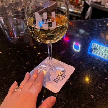 Nick and Jake's - a hand holding a glass of wine - American Near Me - Parkville, Missouri Nick and Jake's - a hand holding a glass of wine - American Near Me - Parkville, Missouri