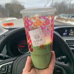  a hand holding a cup of green tea