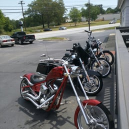 a row of motorcycles parked in a parking lot