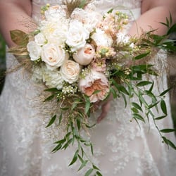 Soft peach and white bridal bouquet featuring garden roses, roses and spray roses, stock, gilded foliage.