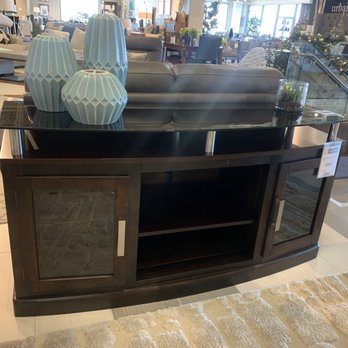 HomeWorld Kapolei - A great entertainment center with silver hardware and touches of glass for a sleek look. - Furniture Stores Near Me - Kapolei, Hawaii