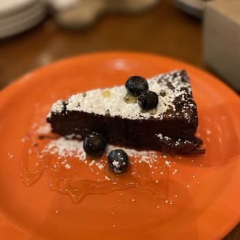 Santiago's Bodega - a piece of chocolate cake on an orange plate - Spanish Near Me - Altamonte Springs, Florida Santiago's Bodega - a piece of chocolate cake on an orange plate - Spanish Near Me - Altamonte Springs, Florida