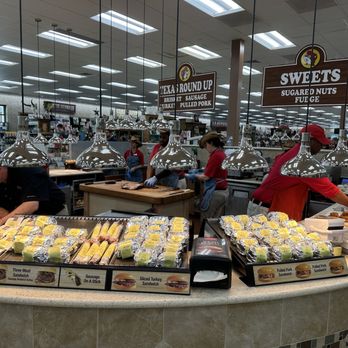 Buc-ee’s - Inside store - A food service counter at Buc-ee's features staff preparing sandwiches and snacks, with signs indicating available items like sausage, turkey, and pulled pork. - Gas Stations Near Me - Saint Augustine, Florida