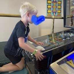 The four year old on the stool he adopted playing one of his favorite pinball games. The four year old on the stool he adopted playing one of his favorite pinball games.