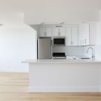 Syros Construction - Showing the open style modern kitchen with a dine in island & bamboo light flooring flowing throughout the apt into the kitchen. - General Contractors Near Me Syros Construction - Showing the open style modern kitchen with a dine in island & bamboo light flooring flowing throughout the apt into the kitchen. - General Contractors Near Me