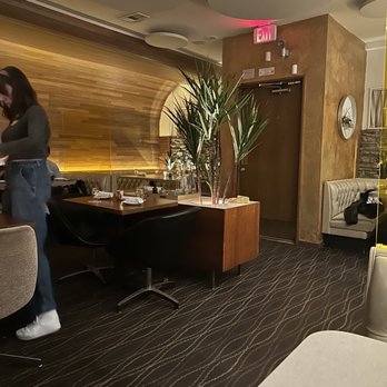 Lounge Here - a woman sitting at a desk - Cocktail Bars Near Me - Dallas, Texas