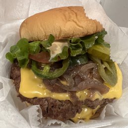 Double cheeseburger with sliced onions, pickles and jalapeños