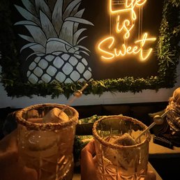 two people holding cocktail glasses two people holding cocktail glasses