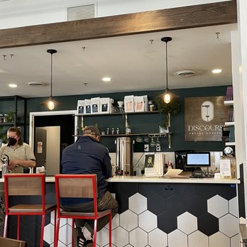Discourse - a man sitting at a counter in a restaurant - Coffee & Tea Near Me - Milwaukee, Wisconsin