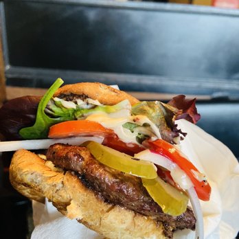 The Tipper Restaurant - a hand holding a sandwich - Burgers Near Me - Vancouver, British Columbia