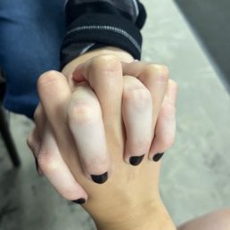 a woman's hand with a black and white manicure