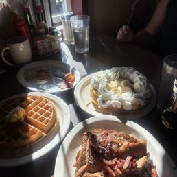 Bacon French toast, banana foster waffle, and waffle with one egg and bacon.