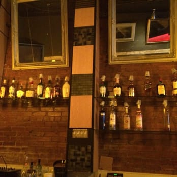 The Lounge - a brick wall with liquor bottles on it - Bars Near Me - Dallas, Texas The Lounge - a brick wall with liquor bottles on it - Bars Near Me - Dallas, Texas