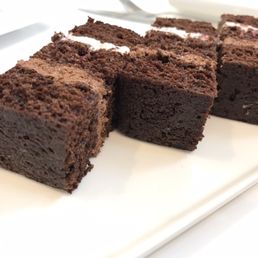 four pieces of chocolate cake on a white plate four pieces of chocolate cake on a white plate