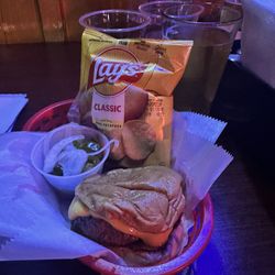 Cheeseburger and a bag is chips