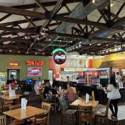 Classic open concept restaurant with wood table tops , centrally located fixins bar and drinks , to the right is the famous bakery