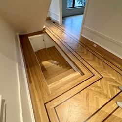 Tom's Hardwood Floors - Engineered white oak herringbone with walnut border strips