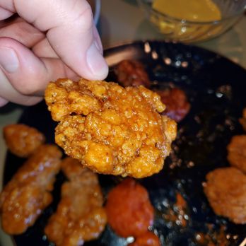 Wingstop - a hand holding a piece of fried chicken - Chicken Wings Near Me - Olathe, Kansas Wingstop - a hand holding a piece of fried chicken - Chicken Wings Near Me - Olathe, Kansas