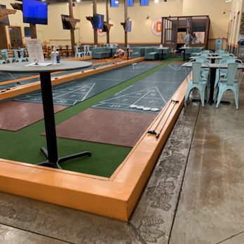 Da Boccery - Shuffleboard with one of the axe throwing booths in the distance. - Axe Throwing Near Me - Livermore, California