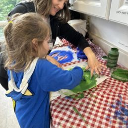 Teacher Tacha helping my daughter paint her Earth Day Shirt.