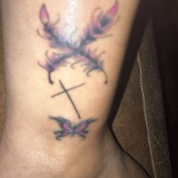 Fat Cat Tattoos & Body Piercing - Quills cross and butterfly I had retouched up that was my very first tattoo at 17