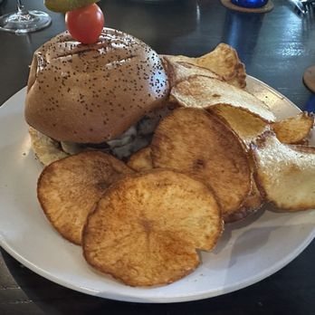 Monaco - THE CHEESEBURGER  double patty, raclette cheese, red onion, aioli, dijon, poppy seed bun w/cornichon, Castelvetrano olive, and cherry tomato - Italian Near Me - Irving, Texas