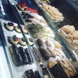 a variety of pastries in a display case a variety of pastries in a display case