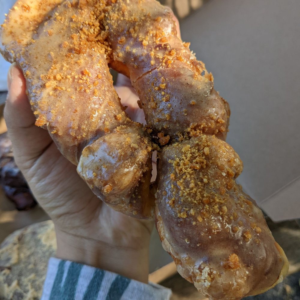 Taylor's Donuts - a hand holding a doughnut - Coffee & Tea Near Me - Lawrence, Kansas