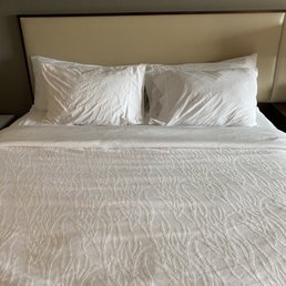 Wrinkly bed that is supposed to be fresh upon my arrival... looks like someone's already slept here.