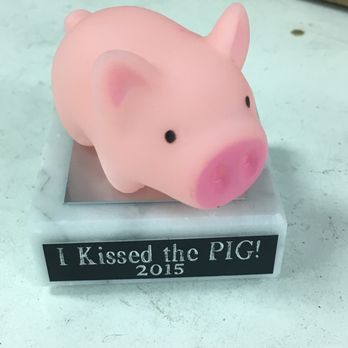 Tempe Trophy - A small pink pig figurine with black eyes and a pink snout sits on a stand with a label reading 'I Kissed the PIG! 2015.' - Trophy Shops Near Me - Tempe, Arizona